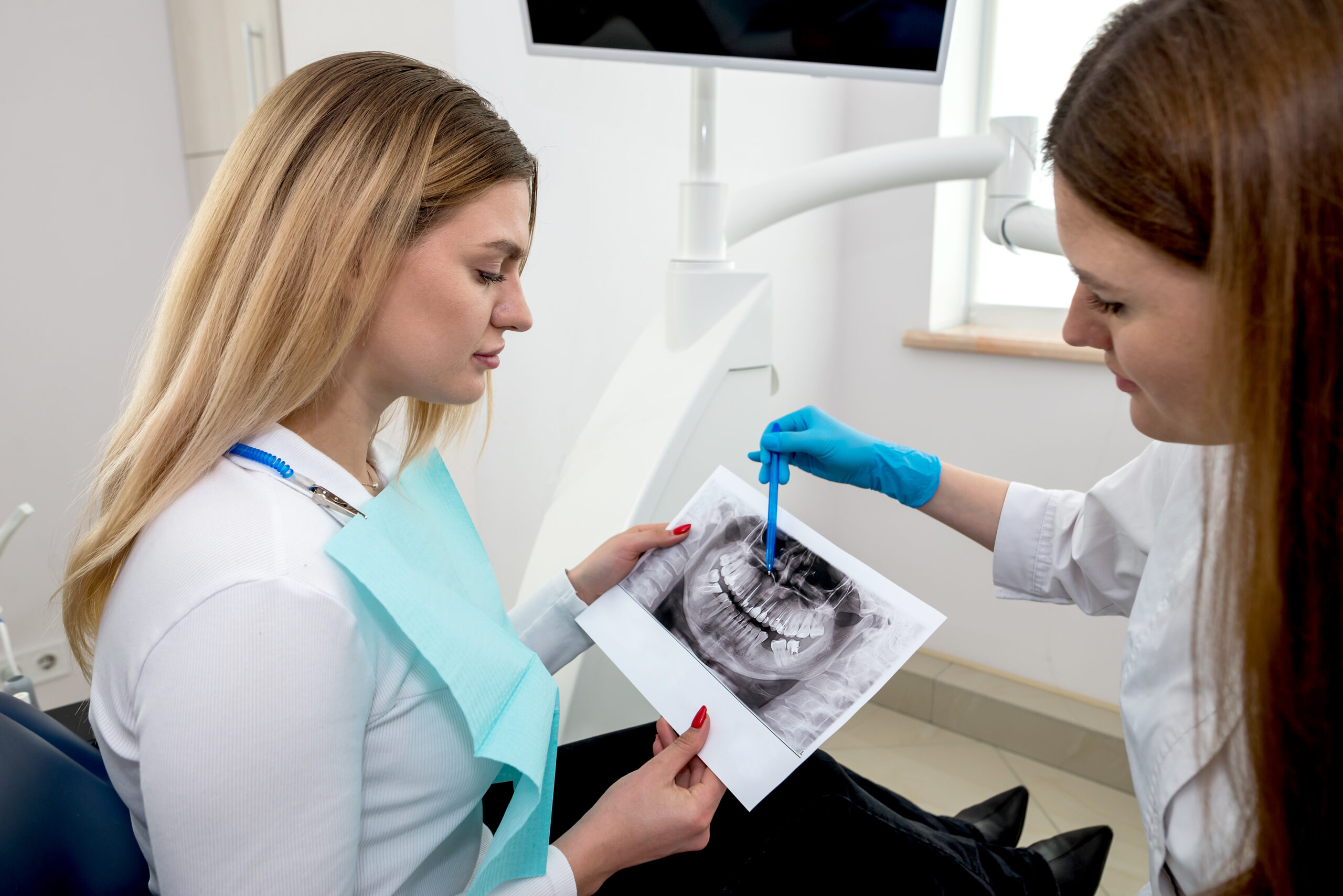 Dentist shows X-Ray Image to patient.