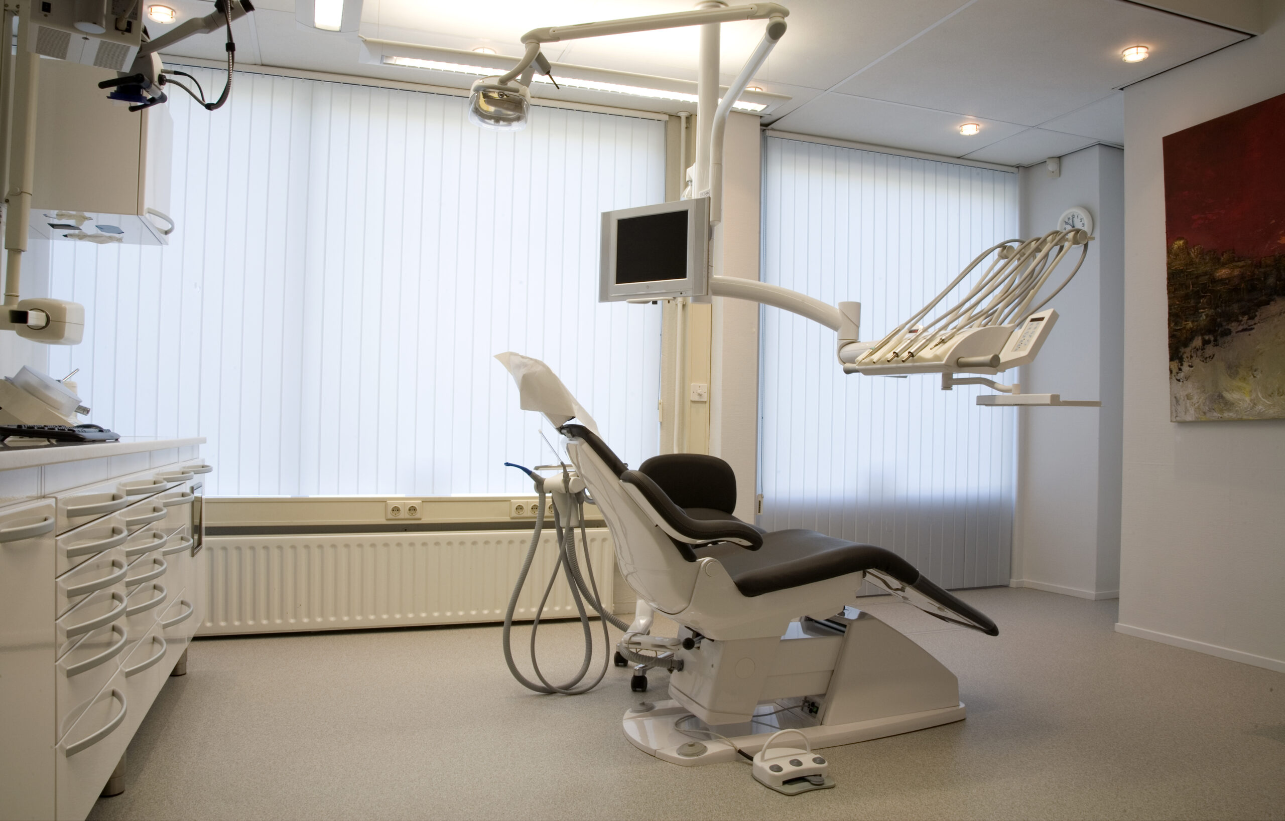 A dentist chair in a room with a large window.
