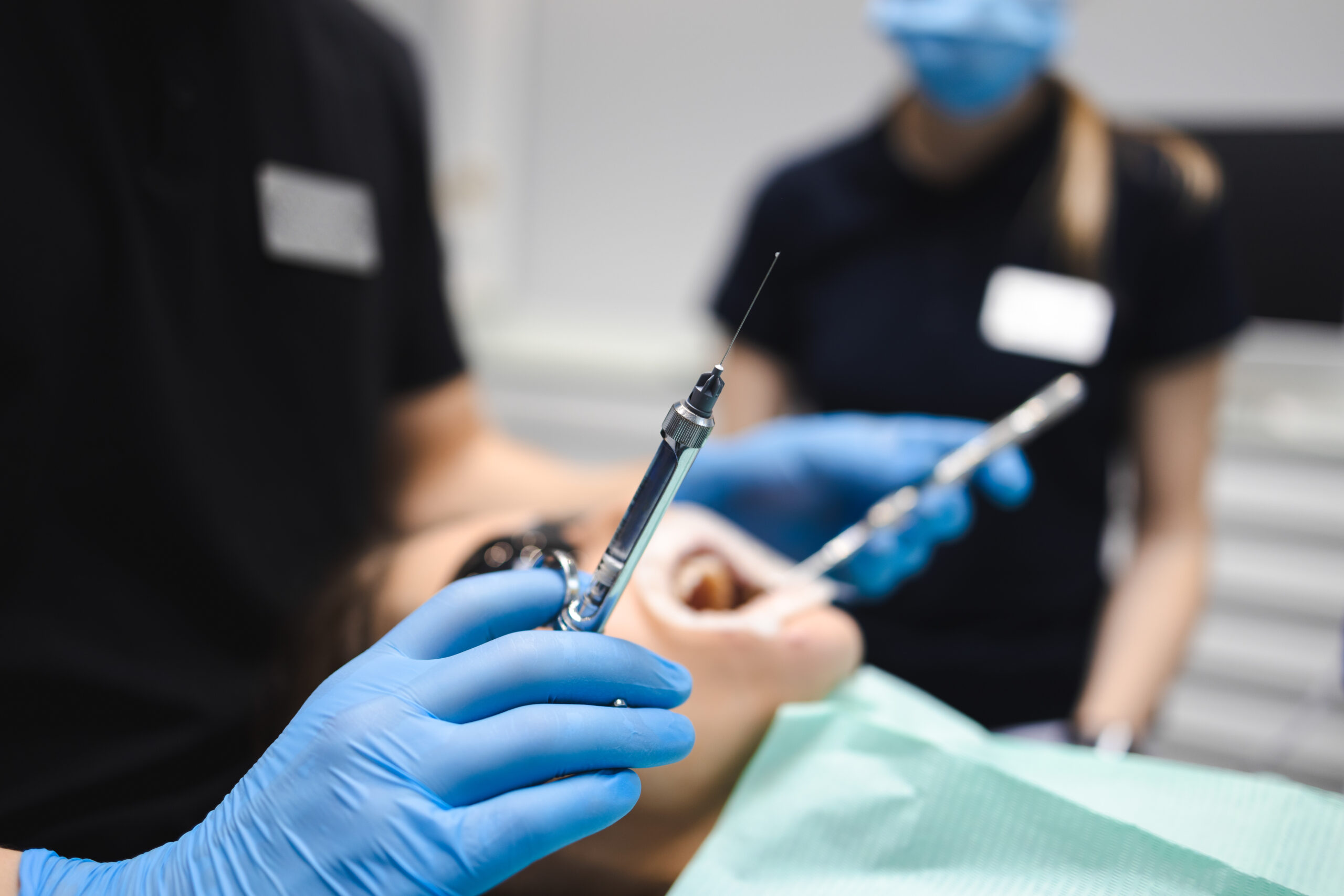 A dentist is about to administer anesthesia before an endodontic procedure.